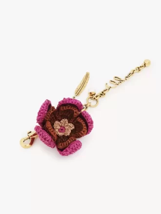 Blommig väskaberlock i raffia och metall Blommig väskaberlock i raffia och metall